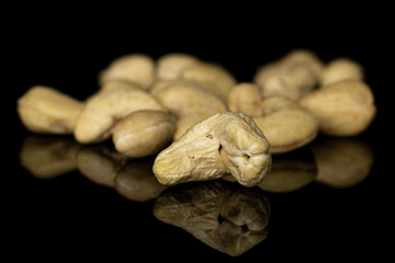 Lot of whole brown nut cashew heap isolated on black glass