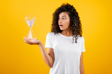 beautiful black woman with hourglass isolated over yellow