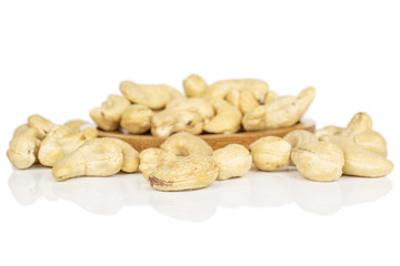 Lot of whole brown nut cashew on round bamboo coaster isolated on white background