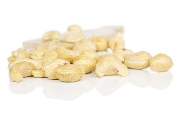 Lot of whole brown nut cashew on wooden cutting board isolated on white background