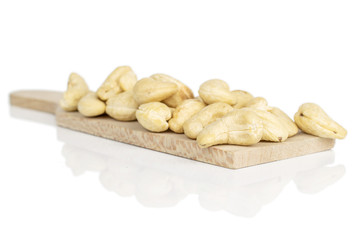Lot of whole brown nut cashew heap on wooden cutting board isolated on white background