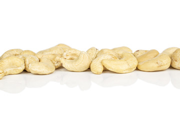Lot of whole brown nut cashew in row isolated on white background