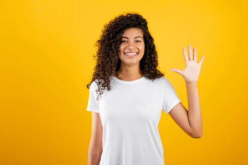 happy black girl showing five fingers isolated over yellow