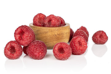 Lot of whole fresh red raspberry in bamboo bowl isolated on white background