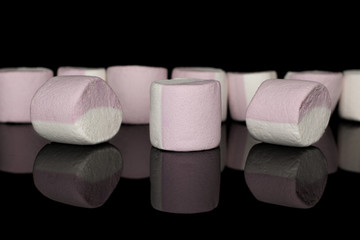 Lot of whole sweet pastel marshmallow isolated on black glass