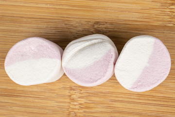 Group of three whole sweet pastel marshmallow flatlay on light wood