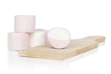 Group of four whole sweet pastel marshmallow on wooden cutting board isolated on white background