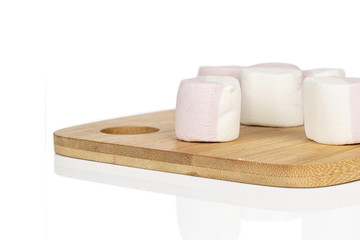 Group of five whole sweet pastel marshmallow on bamboo cutting board isolated on white background