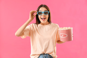 Obraz premium Surprised woman with popcorn on color background