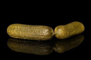 Group of two whole sour green pickle isolated on black glass