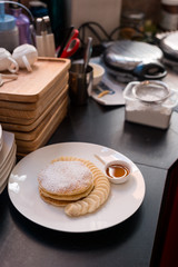 three pancakes with banana in white dish