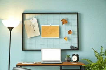 Modern stylish workplace with laptop near color wall