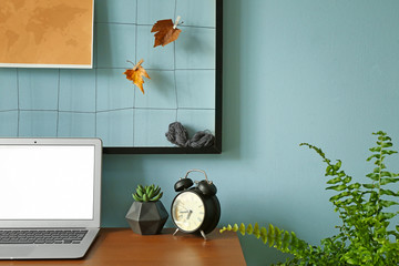 Modern stylish workplace with laptop near color wall