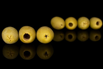 Group of seven whole marinated green olive isolated on black glass