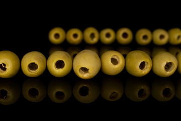 Group of fifteen whole marinated green olive isolated on black glass