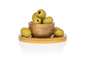 Group of six whole marinated green olive on round bamboo coaster in bamboo bowl isolated on white background