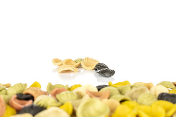 Lot of whole arranged colorful pasta orecchiette back focus isolated on white background