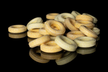 Lot of whole round pale yellow candy heap isolated on black glass