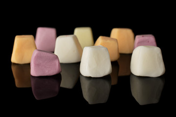 Lot of whole soft pastel candy front focus isolated on black glass