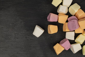 Lot of whole soft pastel candy flatlay on grey stone