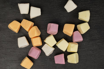 Lot of whole soft pastel candy flatlay on grey stone