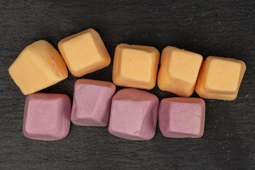 Lot of whole arranged soft pastel candy flatlay on grey stone