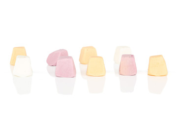 Lot of whole soft pastel candy in row isolated on white background