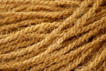 Rough Cord made from natural plant fiber. Rope detail, closeup. Wallpaper and background about fabtic manufacture, eco friendly material. Horizontal. Brown tone. Copy space. Selective focus