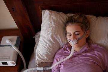 Sleeping on back with cpap machine young female