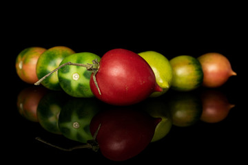 Group of seven whole fresh tomato de barao triangle isolated on black glass