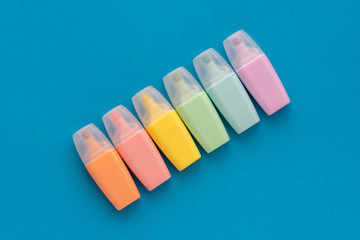 Highlighters set on colored blue background. Collection of markers different color. Flat lay, top view. Back to school, education concept.