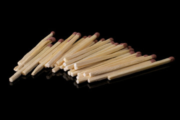 Lot of whole wooden brown safety match isolated on black glass
