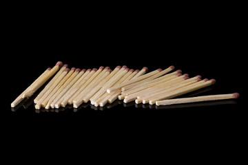Lot of whole wooden brown safety match isolated on black glass
