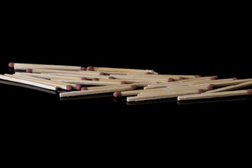 Lot of whole wooden brown safety match in row isolated on black glass
