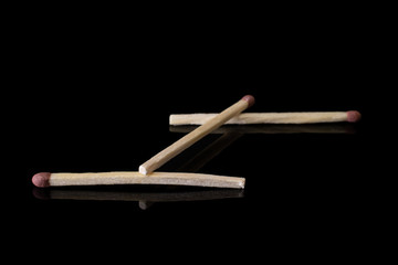 Group of three whole brown safety match isolated on black glass