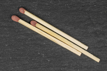 Group of three whole brown safety match flatlay on grey stone