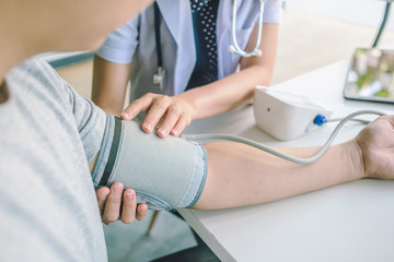 doctor woman checking blood pressure of male patient and heart rate with digital pressure gauge ,Cardiology in medicine and health care concept