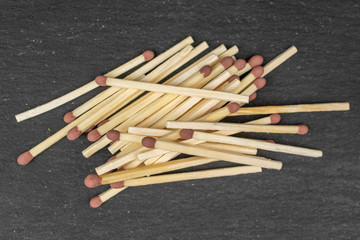 Lot of whole wooden brown safety match heap flatlay on grey stone