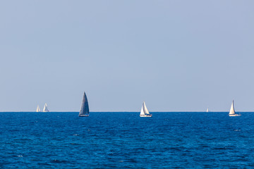 Several yacht with white and gray sail on Mediterranean Sea