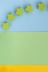 Kids toys on pastel blue green paper yellow background. Top view on children's educational games. Wooden stars. Flat lay, copy space.