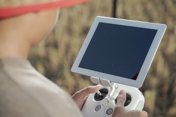 Asian farmers oversee his fields with sophisticated technology