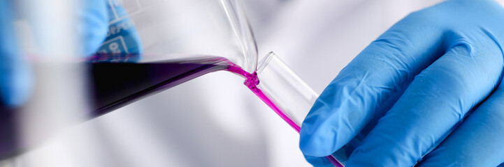 A male chemist holds test tube of glass in