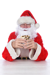 Closeup of Santa Claus holding a mug of hot cocoa with toasted marshmallows and chocolate syrup drip, isolated on white.