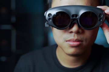 close up man wearing AR glasses in a dark room