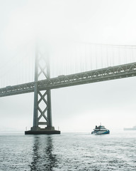 Foggy bay bridge and ferry