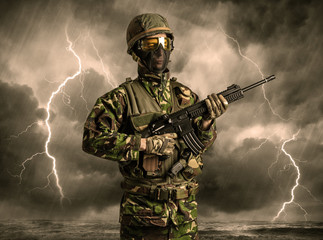 Armed soldier standing in rainy obscure weather