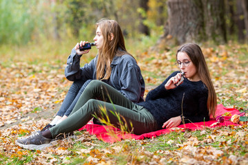 Vape lgbt teenagers. Bisexual lesbian young caucasian teenage girls in casual clothes vape...