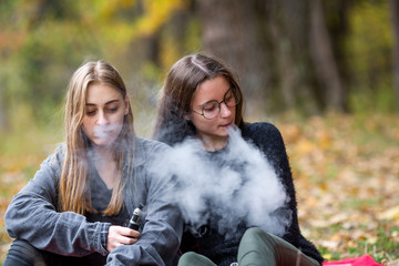 Vape lgbt teenagers. Bisexual lesbian young caucasian teenage girls in casual clothes vape...
