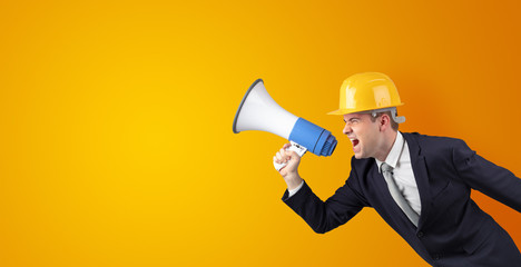 Fototapeta premium Young architect constructor yelling with megaphone and copyspace