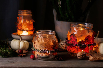 Autumn lantern jars decorated with colorful leaves and heather wreath